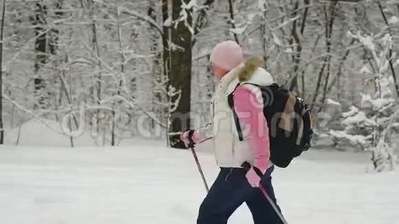 冬天在树林里的女人4这位领取养老金的人用特别的棍子打着他的木头视频的预览图