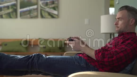 在沙发上玩电子游戏的人视频的预览图