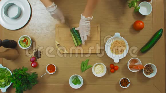 女性手切黄瓜番茄鱼牛至沙司奶酪俯视图视频的预览图