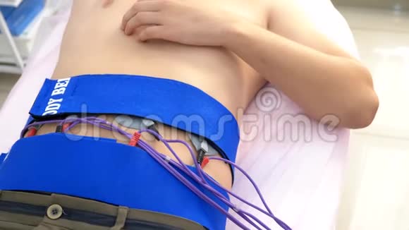 特写镜头腹部肌肉的电刺激程序一个人被动地刺激腹部肌肉视频的预览图