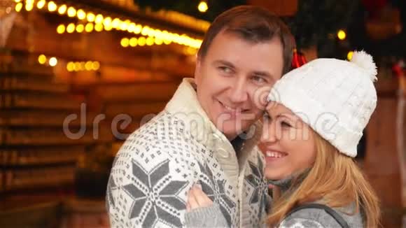 幸福的年轻夫妇一起穿着温暖的衣服在后台庆祝圣诞节在圣诞节欢笑视频的预览图