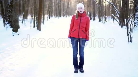 迷人的年轻女子在冬天的公园里跳着滑稽和愚蠢的舞蹈玩得很开心微笑着慢动作视频的预览图