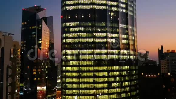 日落时摩天大楼的发光窗口阿布扎比的现代办公室和塔楼景观视频的预览图