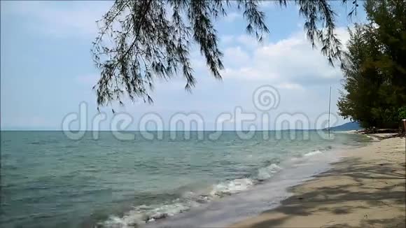 海浪拍打着阳光明媚的蓝天下的沙滩视频的预览图