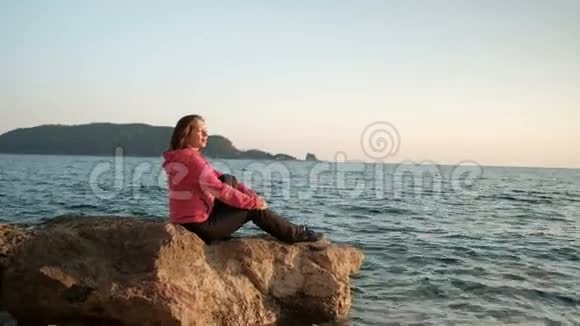 年轻女子坐在室外的水上视频的预览图