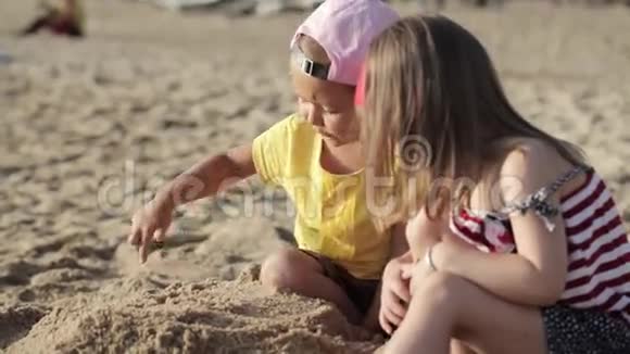 两个可爱的小女孩在沙滩上玩沙子视频的预览图