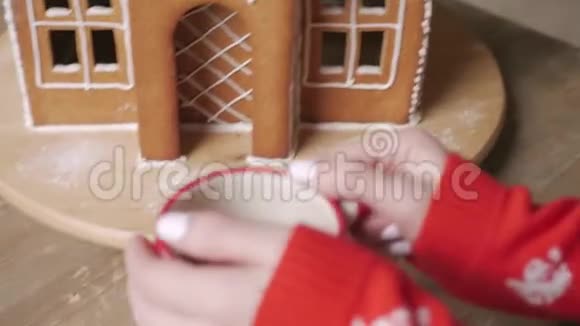 一位穿着冬装的美女在家附近的圣诞树旁喝着带姜饼的茶视频的预览图