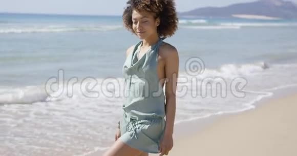 穿着夏季连衣裙在沙滩上摆姿势的女性视频的预览图