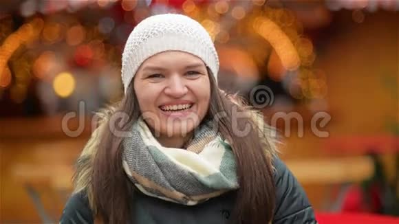 在阳光明媚的冬日快乐的女人肖像户外女孩笑着看着镜头圣诞节集市视频的预览图