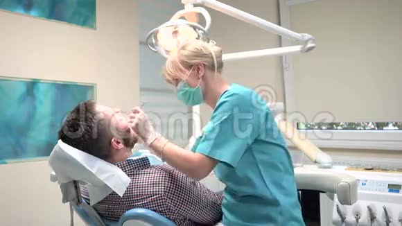 牙医检查病人牙齿解释他的程序视频的预览图