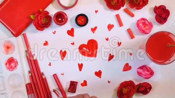 红色调色板许多人的心被画在纸上从上面的艺术家办公桌情人节或母亲节的概念视频的预览图