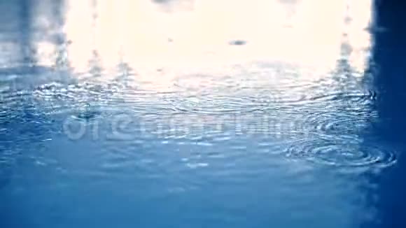 雨水缓慢地滴在蓝水上视频的预览图