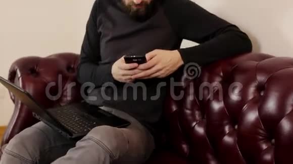 戴手提电脑和智能手机的胡子男视频的预览图
