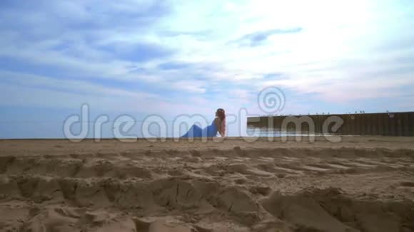 女人放松海滩美丽的女人躺在海边穿蓝色裙子的女人视频的预览图