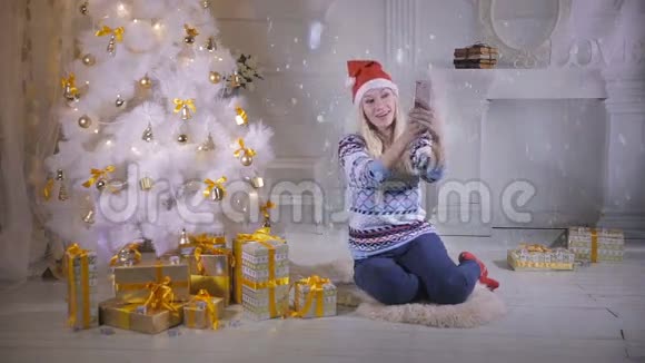圣诞前夜一位年轻漂亮的女士在圣诞树附近自拍新年自拍照片视频的预览图