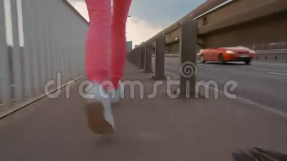 斯良德女跑步者在桥上慢跑特写后景视频的预览图