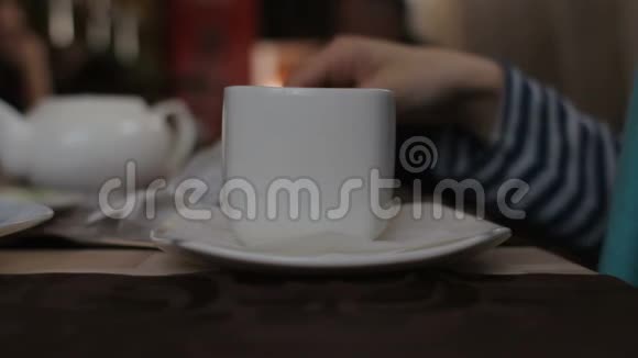 无名女子坐在咖啡馆里把柠檬放进白杯里视频的预览图