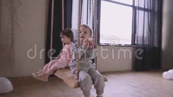 双胞胎姐妹一起玩耍在房子里跑来跑去骑着秋千视频的预览图