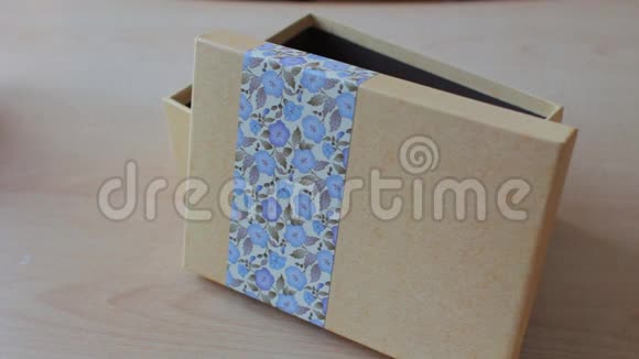 双手合上一个礼物盒假日概念米色和蓝色视频的预览图