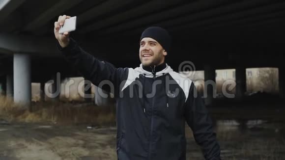 冬天在城市户外训练后快乐的运动男用智能手机自拍视频的预览图