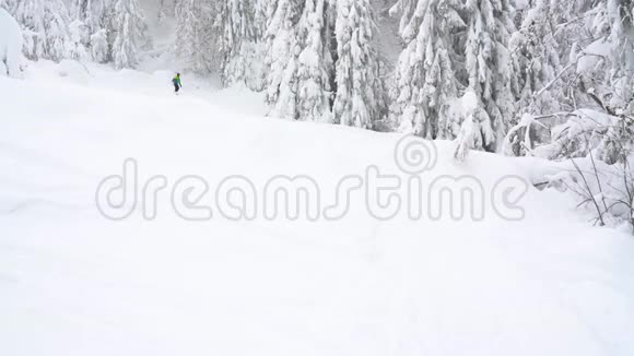 极限滑雪者骑着新鲜的粉末雪下陡峭的山坡视频的预览图
