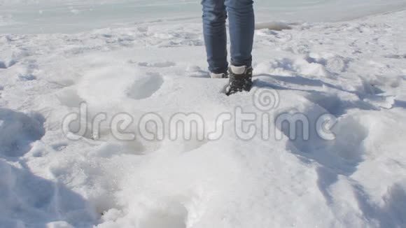 穿着牛仔裤和穿着冬鞋在大雪中行走的无名女性视频的预览图