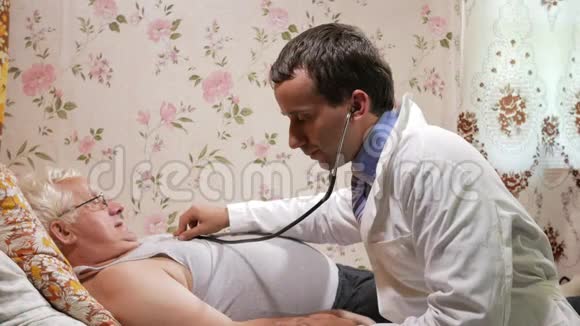 一位男医生在家用听音筒听病人说话那个人躺在沙发上视频的预览图