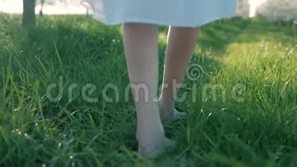 少女光着脚在绿草上行走和奔跑的慢镜头视频的预览图