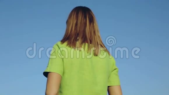 那个穿着绿色衣服的女孩站在成熟的麦穗中的田野里视频的预览图