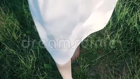 少女光着脚在绿草上行走和奔跑的慢镜头视频的预览图