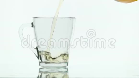 绿茶从白色背景的茶壶中倒入玻璃杯视频的预览图