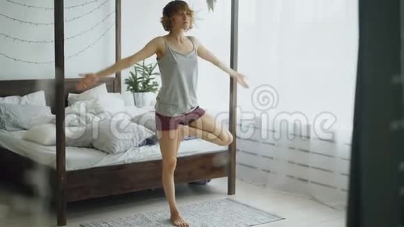 一位年轻的美女在卧室的床旁做瑜伽运动视频的预览图