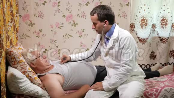 一位男医生在家用听音筒听病人说话那个人躺在沙发上视频的预览图