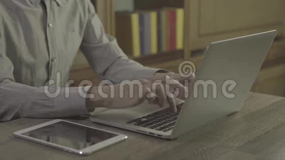 年轻人用笔记本在桌子上视频的预览图