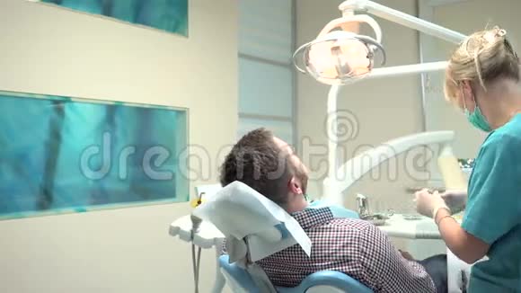 牙科诊所的女牙医钻牙术是的是的视频的预览图