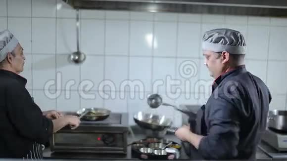 两个厨师正在厨房准备菜视频的预览图