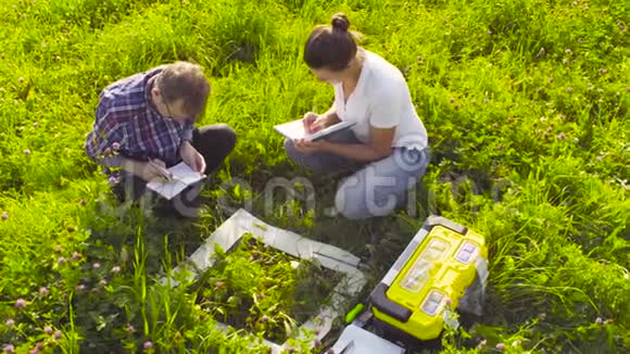 两位生态学家研究草地上的植物视频的预览图