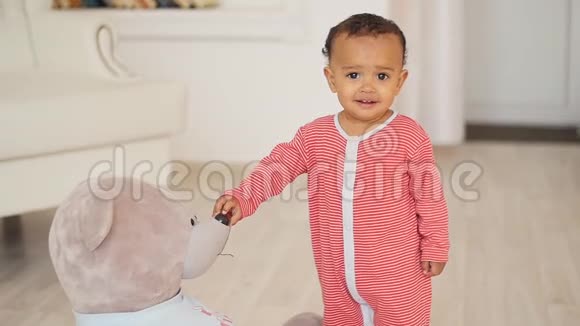 可爱微笑的非洲宝宝带着玩具熊玩具视频的预览图