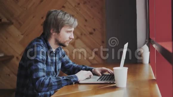年轻人在酒吧里拿着笔记本电脑喝着一杯卡布奇诺现代咖啡馆视频的预览图