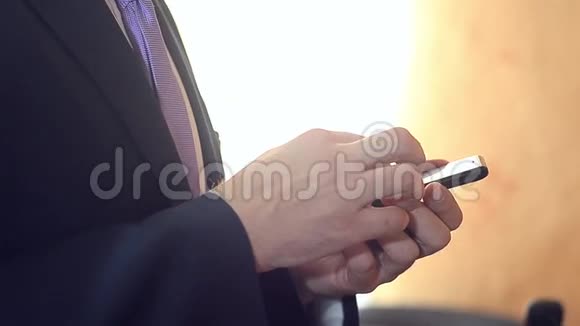 商人检查智能手机电子邮件一个穿西装的男人并在你的手机上打领带阅读新闻视频的预览图
