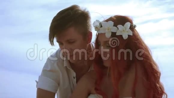 喜欢在天空背景下接吻的情侣红发女人吻她丈夫视频的预览图