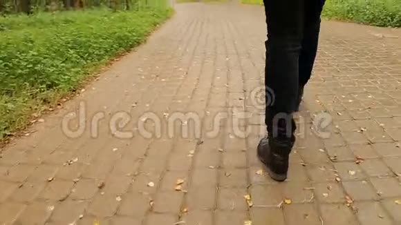 穿黑鞋和牛仔裤的女性脚在路上视频的预览图