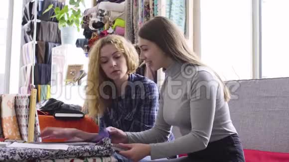 两个年轻妇女在一家纸巾店买布微笑说话视频的预览图