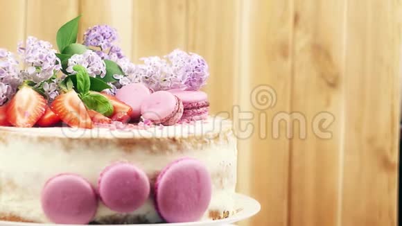 自制蛋糕上面装饰着草莓马卡龙和丁香花4K慢潮内部拍摄视频的预览图
