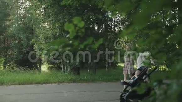 有个户外小宝宝的幸福家庭妈妈爸爸和宝宝在绿色的夏天公园里一起玩视频的预览图
