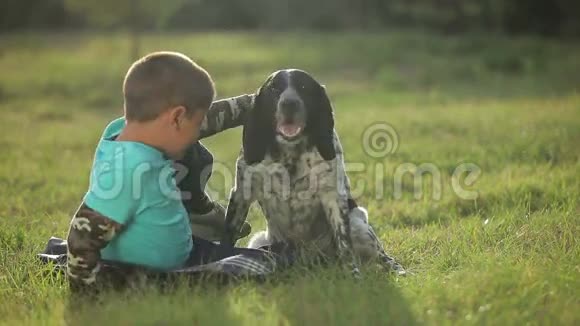一个狗坐在草地上的男孩视频的预览图