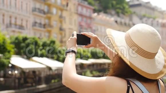 旅行女孩用智能手机捕捉旧城的形象视频的预览图