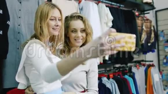 两个朋友在服装店自拍微笑成功快乐购物视频的预览图