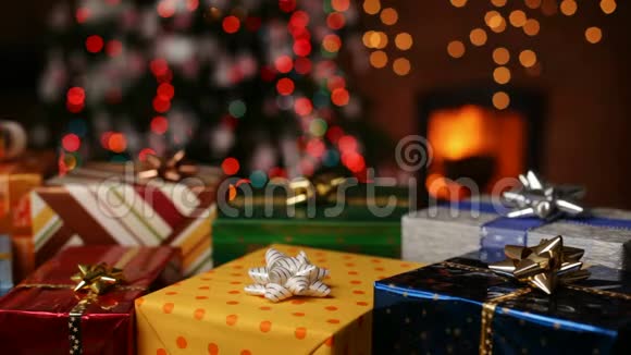 壁炉前的圣诞礼物和圣诞树上模糊的灯光视频的预览图