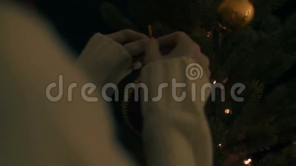 女人把红色圣诞球挂在树上视频的预览图